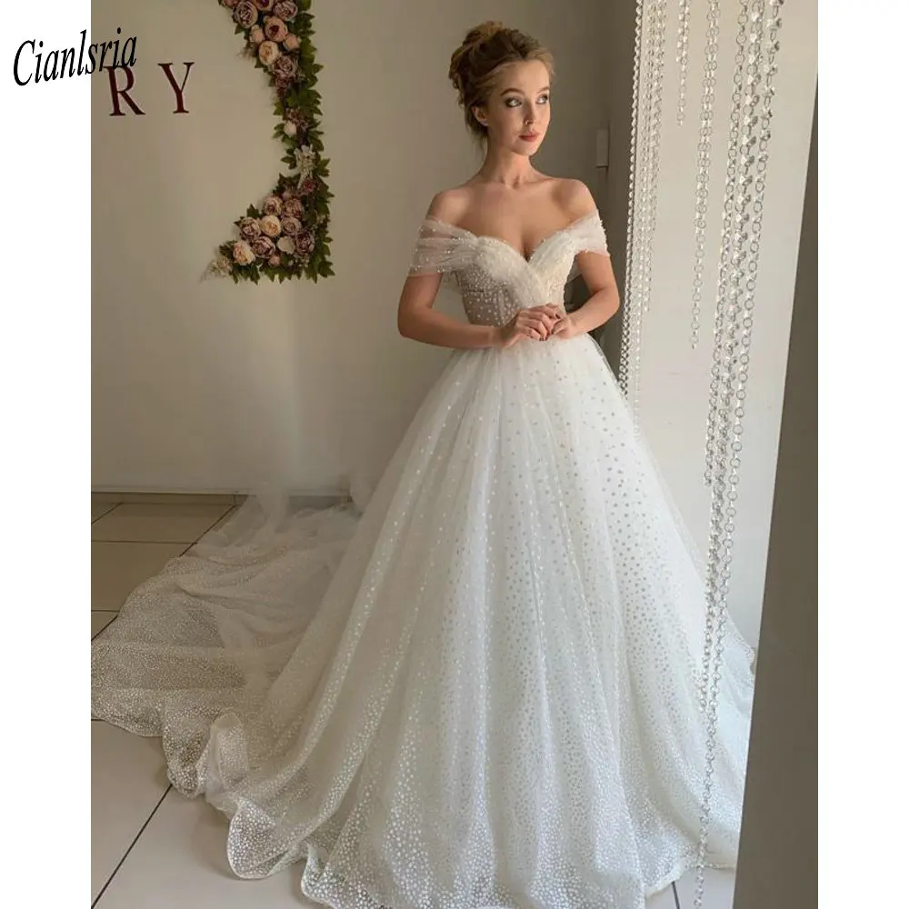 Chic Pearls Beading Off The Shoulder Ball Gown Wedding Dress Sparkly Crystal Tulle Short Sleeve Pleat Open Back Bridal Gown
Chic Pearls Beading Off The Shoulder Ball Gown Wedding Dress Sparkly Crystal Tulle Short Sleeve Pleat Open Back Bridal Gown