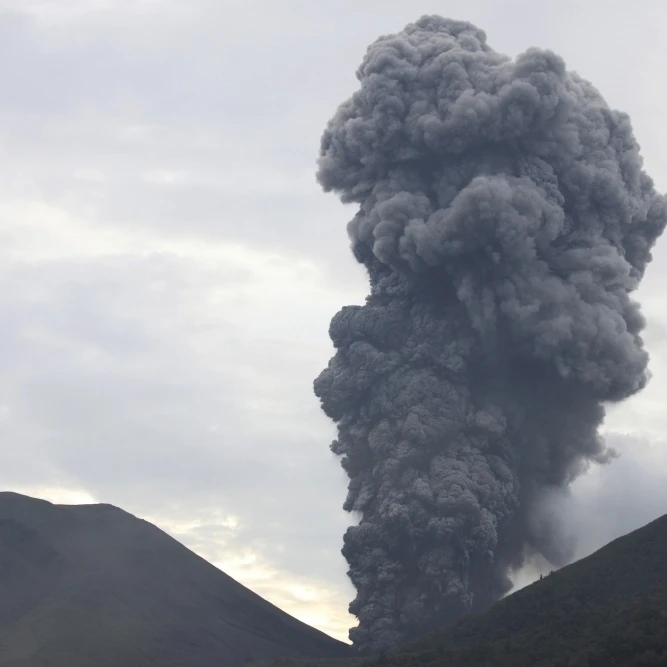 Фото Пепельное облако восходящее от кратера Tompaluan на вулкан локон - купить
