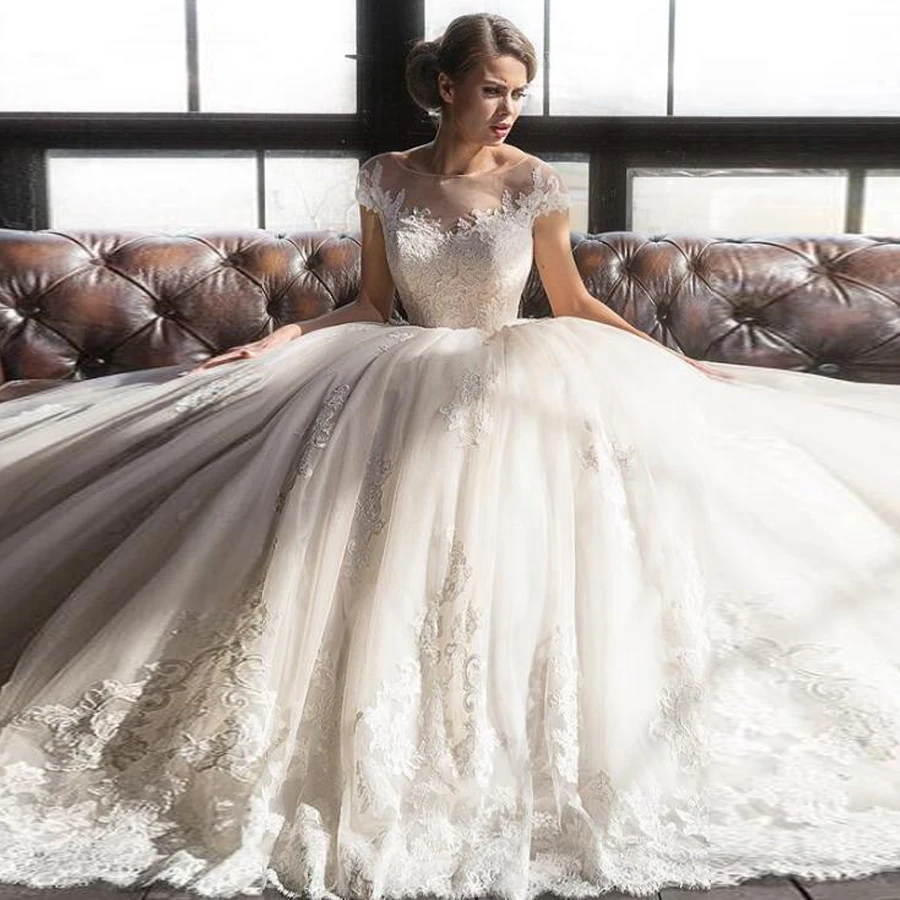 Lavish O-neck Neckline Ball Gown Wedding Dresses with Lace Appliques Illusion Button Back Court Train Bridal Dress
Lavish O-neck Neckline Ball Gown Wedding Dresses with Lace Appliques Illusion Button Back Court Train Bridal Dress