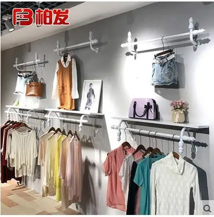 The wall hangers of iron arts clothing store have a vintage display rack of men's and women's clothes racks
The wall hangers of iron arts clothing store have a vintage display rack of men's and women's clothes racks