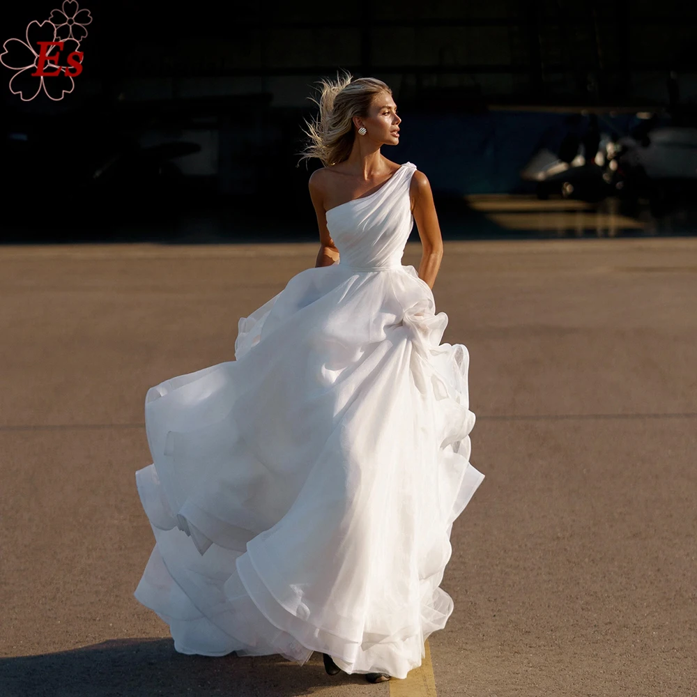 Elegant One Shoulder Wedding Bride Dress 2022 Ruffles Aline Sleeveless Organza Sweep Train Beach Bridal Gown vestido de noiva 
Elegant One Shoulder Wedding Bride Dress 2022 Ruffles Aline Sleeveless Organza Sweep Train Beach Bridal Gown vestido de noiva