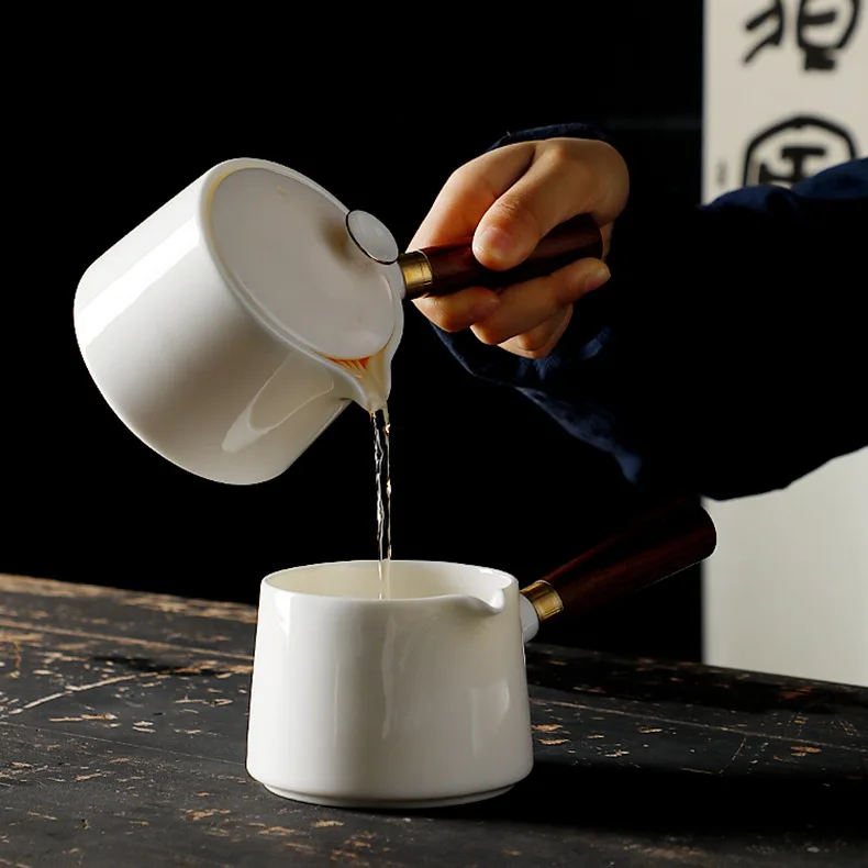 

Kung Fu Tea Set Accessories Tea Pot Of White Porcelain Teapot With Wooden Handle Against The Hot Side