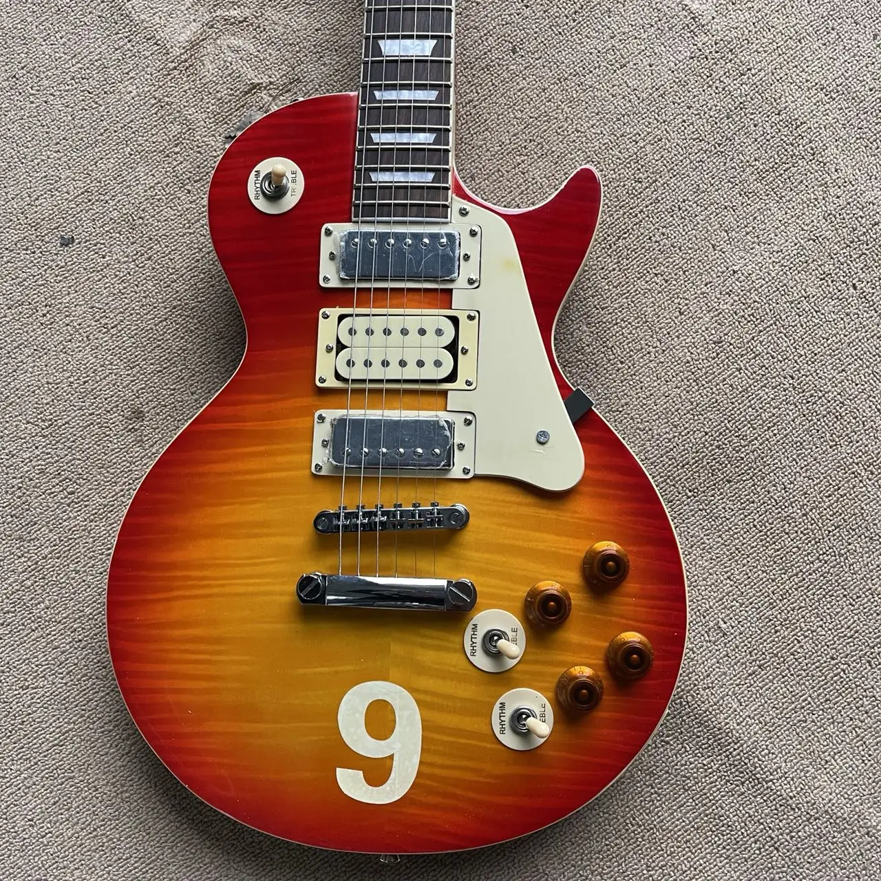 LP all-in-one electric guitar, tomato color tiger pattern veneer mahogany body, 3 pickups, LP string bridge, rosewood fingerboar
LP all-in-one electric guitar, tomato color tiger pattern veneer mahogany body, 3 pickups, LP string bridge, rosewood fingerboar