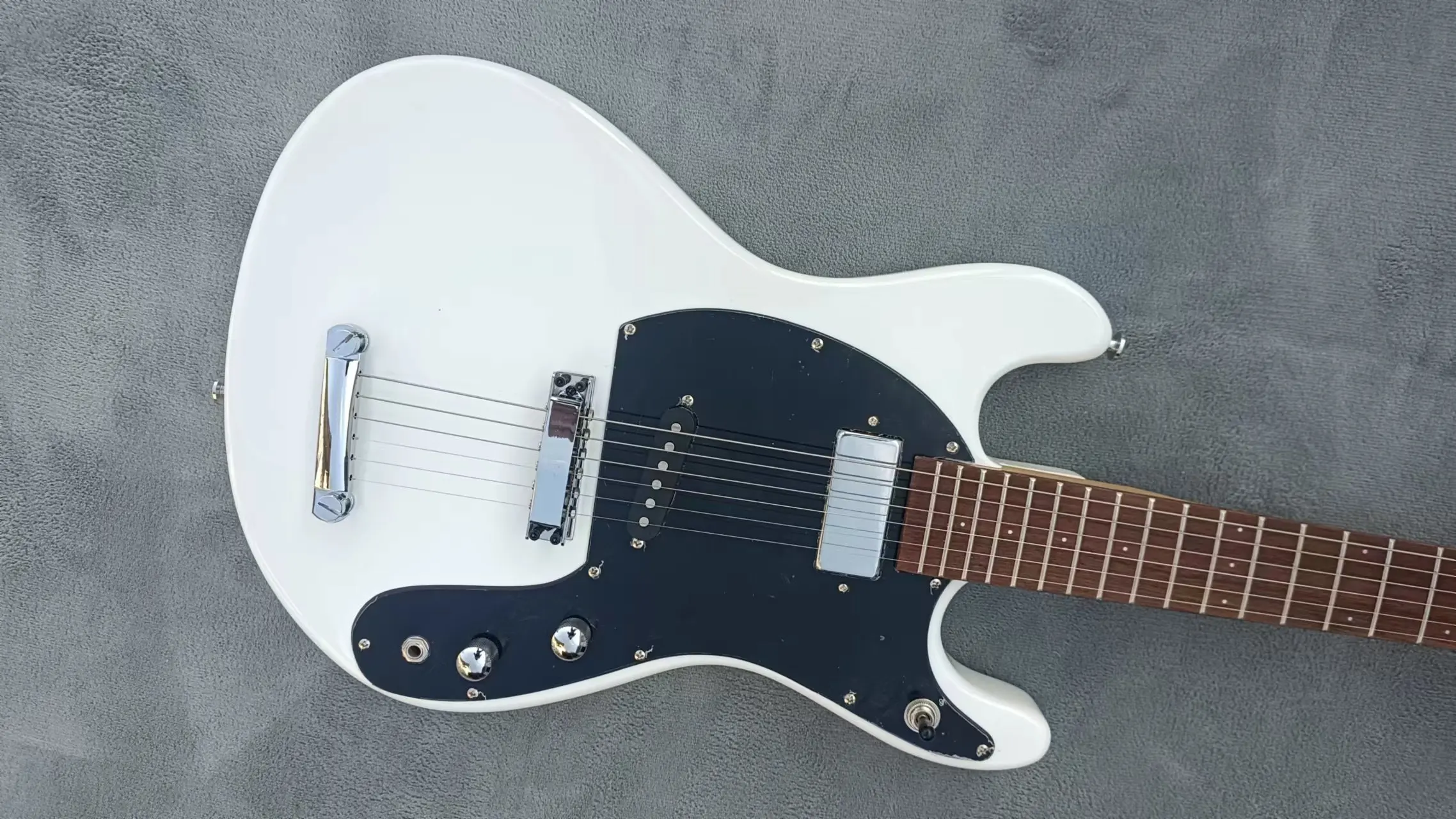 Small foot shaped electric guitar, with white body connected separately, large guard board cover bridge, metal white pieces, can
Small foot shaped electric guitar, with white body connected separately, large guard board cover bridge, metal white pieces, can