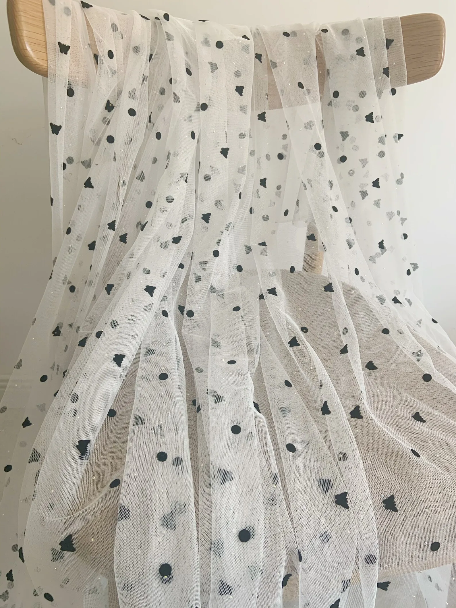 

Из белой тюлевой ткани с черными бархатными бабочками в горошек и стразы для реквизита, платья, костюма