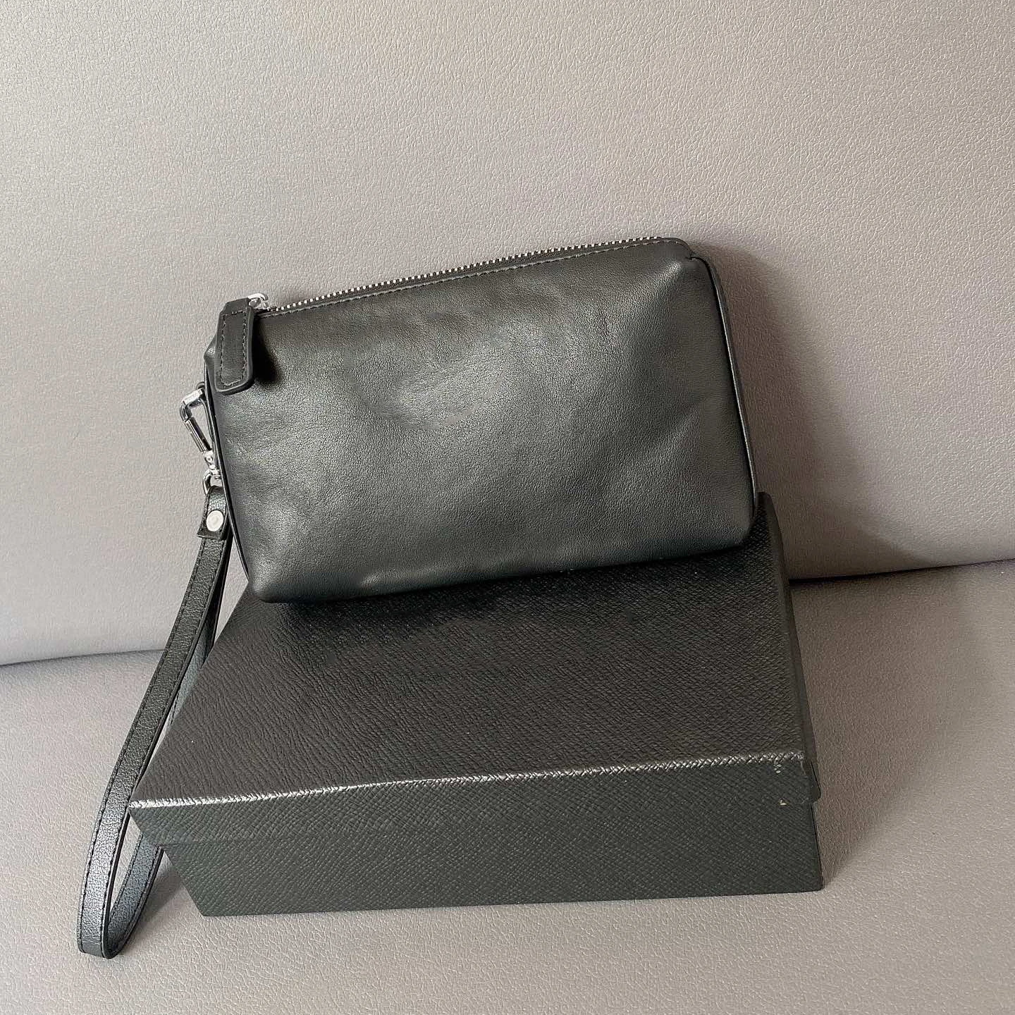 

2022 New Men and Women Fashion Casual High quality genuine cowhide Black Wrist Bag Luxury Designer Clutch Toiletry Bag Wallet