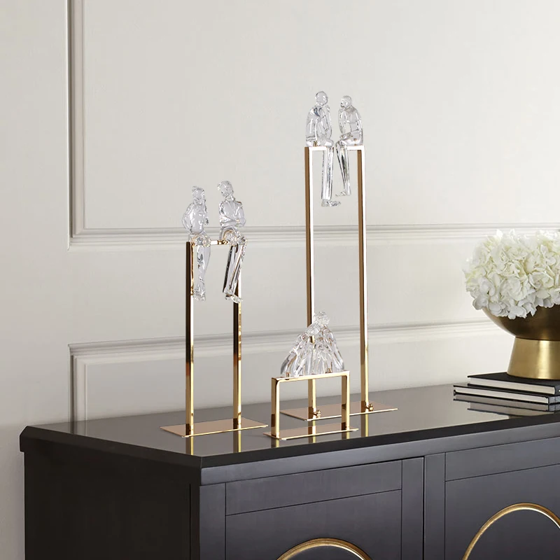 Творческая пара прозрачных абстрактных фигурок из смолы сидя на металлической