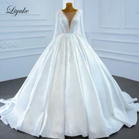liyuke exquisite luxury pearls long sleeve ball gown wedding dress with deep v neck beads satin skirt bridal gown