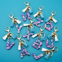 1pcs women keychains 26 glitter hollowed out words handbag tassel english letter keyring with puffer ball charms