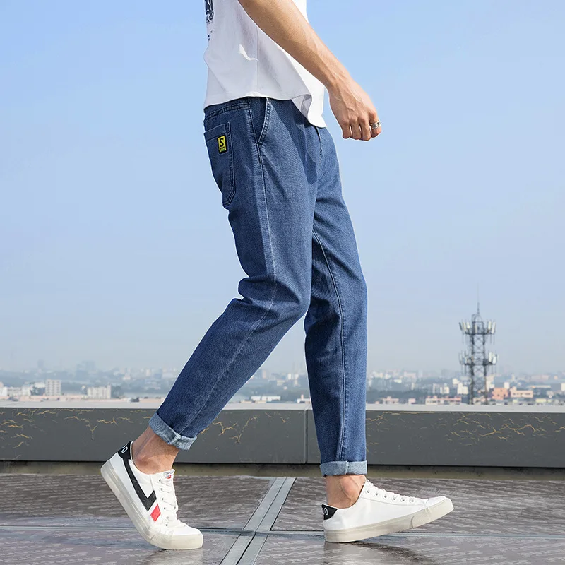 

Elasti-waist loose-fitting jeans are a trend for men with straight and light-colored Harlan trousers