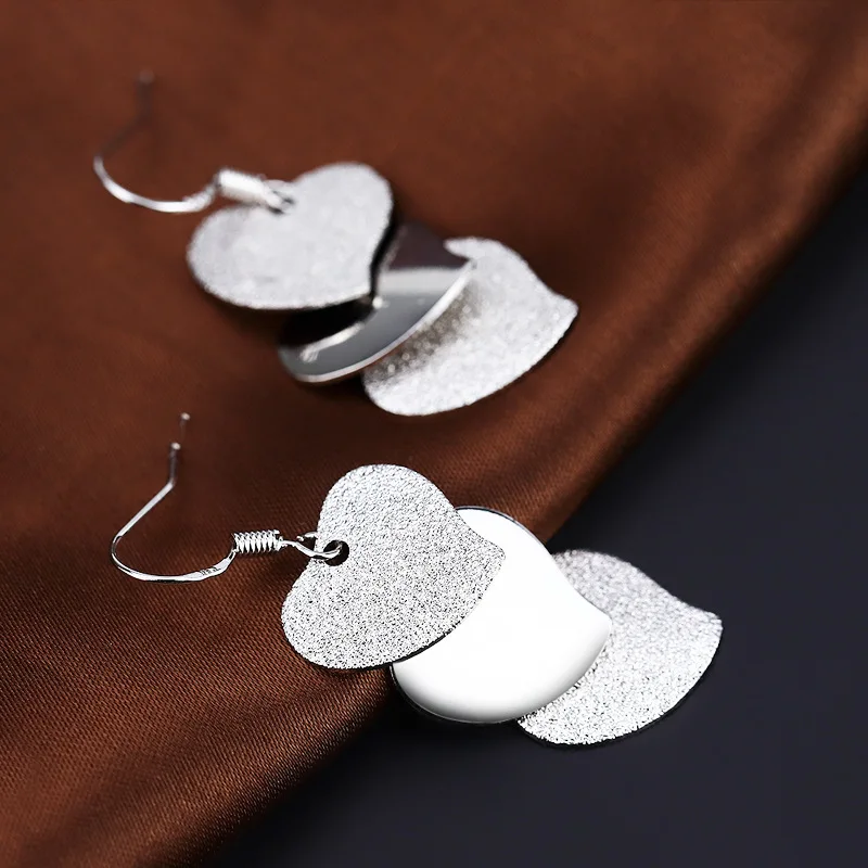 Женские сережки в форме сердца серебристого цвета матовые среднего размера для