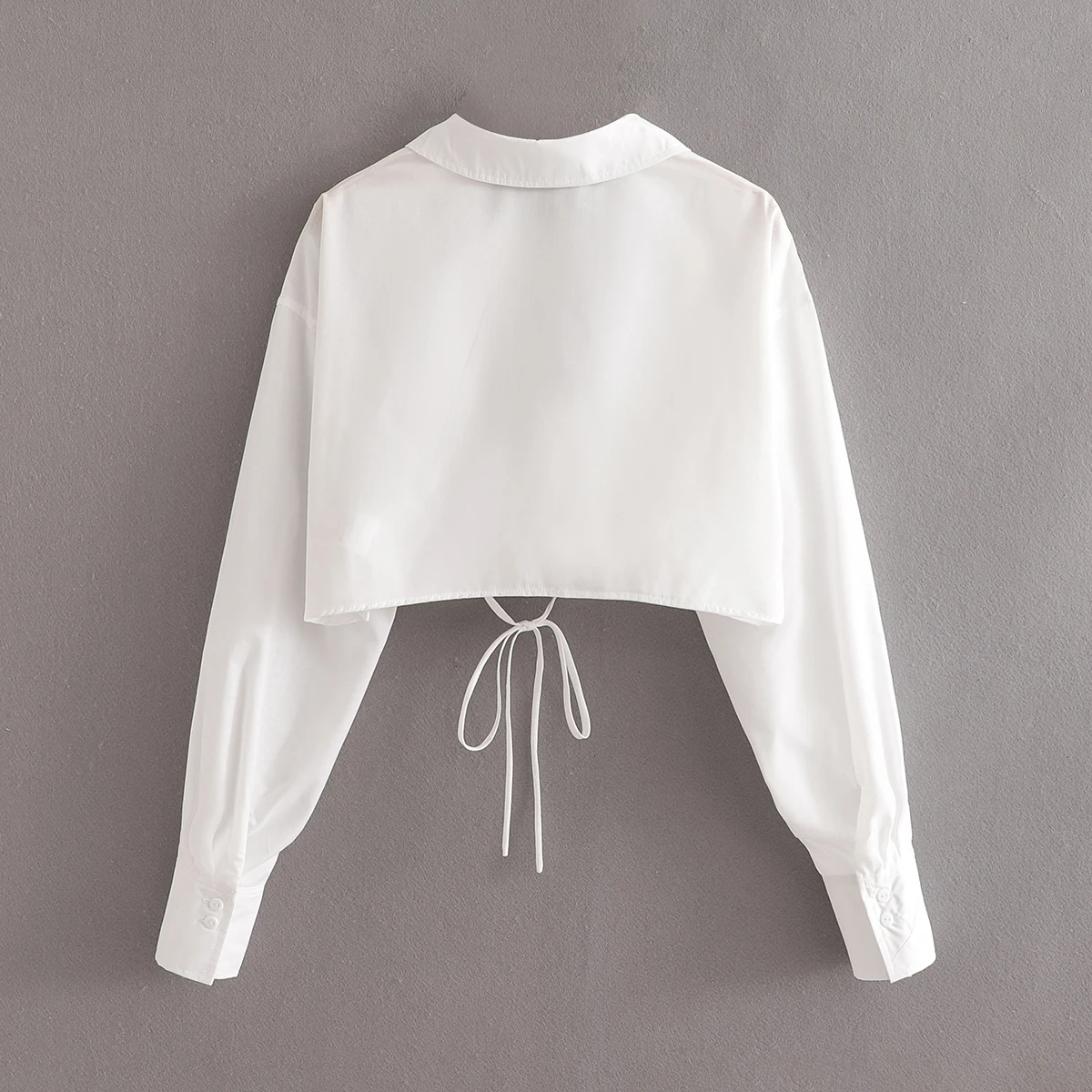 Женский короткий топ KEYANKETIAN двубортный белого цвета с V-образным вырезом и бантом