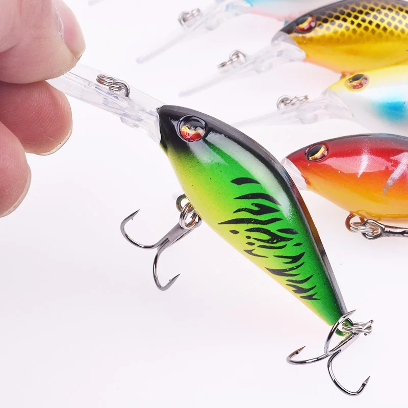 Una mano sostiene un señuelo de pesca con un cuerpo colorido y un gancho