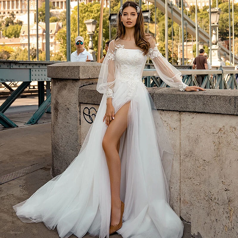 

Свадебное платье для невесты 2021 с пышными рукавами и глубоким круглым вырезом из тюля с кружевной аппликацией с высоким разрезом трапециев...