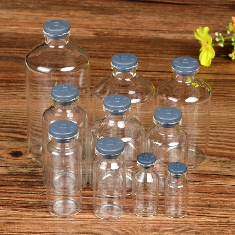 empty sample bottle, clear glass bottle, gray rubber stopper, vial for medical use, sealed injection vial stoppe