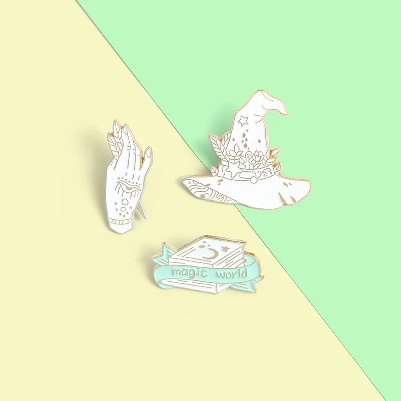 

1PC Witch Book Hat Hand Enamel Pin Custom Starry Magic World Brooch Bag Clothes Lapel Pin White Gothic Badge Witchcraft Jewelry