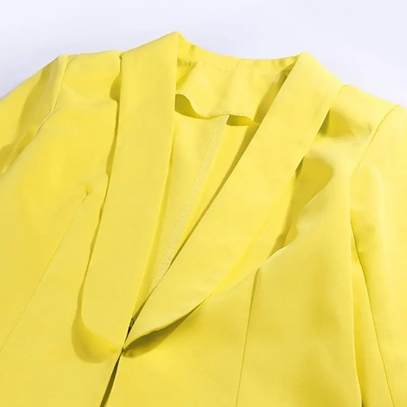 Женский костюм желтый с глубоким треугольным вырезом и штанами для интервью