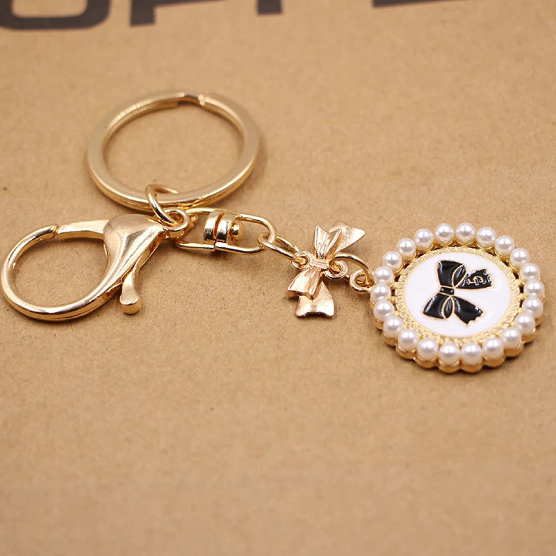 

Fashion Bowknot Keychain Earphone Round Card Pendant Keychain Student Schoolbag Alloy Round Pearl Bowknot Ornament Decoration