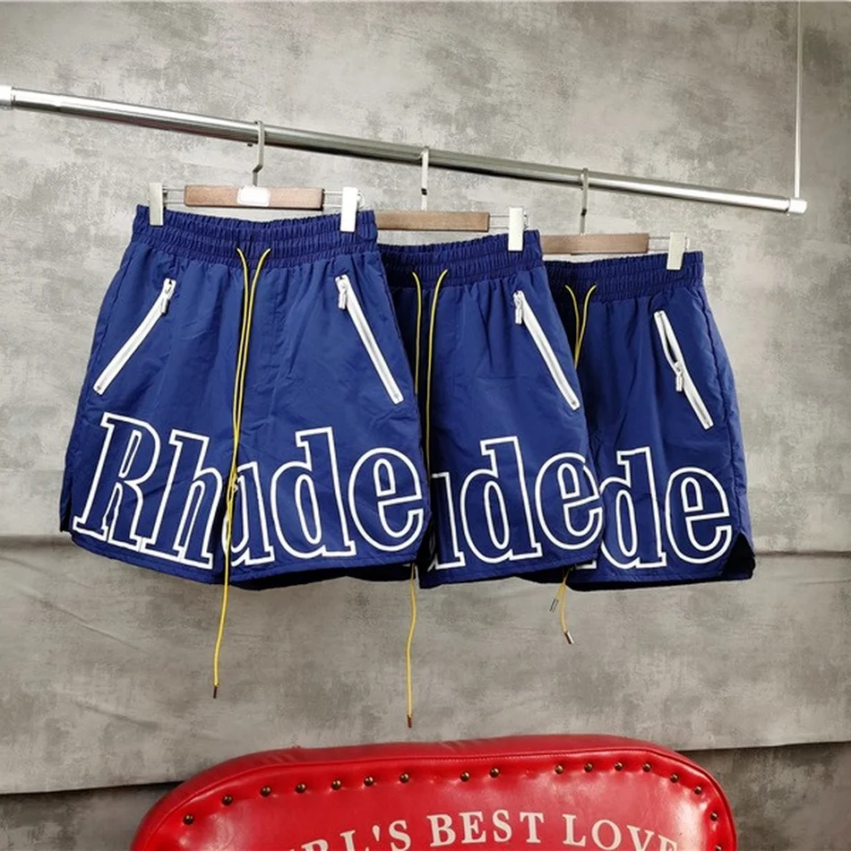 

Blue RHUDE Logo Shorts Men Women PREMIUM NYLON Rhude Shorts TWIN ZIPPER POCKETS EXTENDED DRAWSTRINGS Breeches