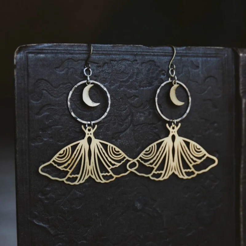 

night fauna. a pair of boho moon and moth cutout mixed metal earrings