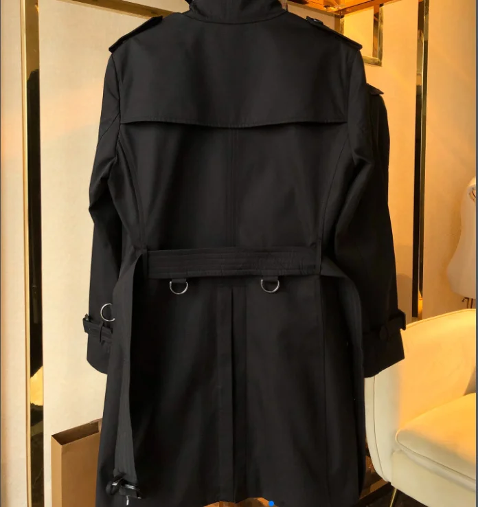 

A long trench coat in khaki and black in the classic British men's trench