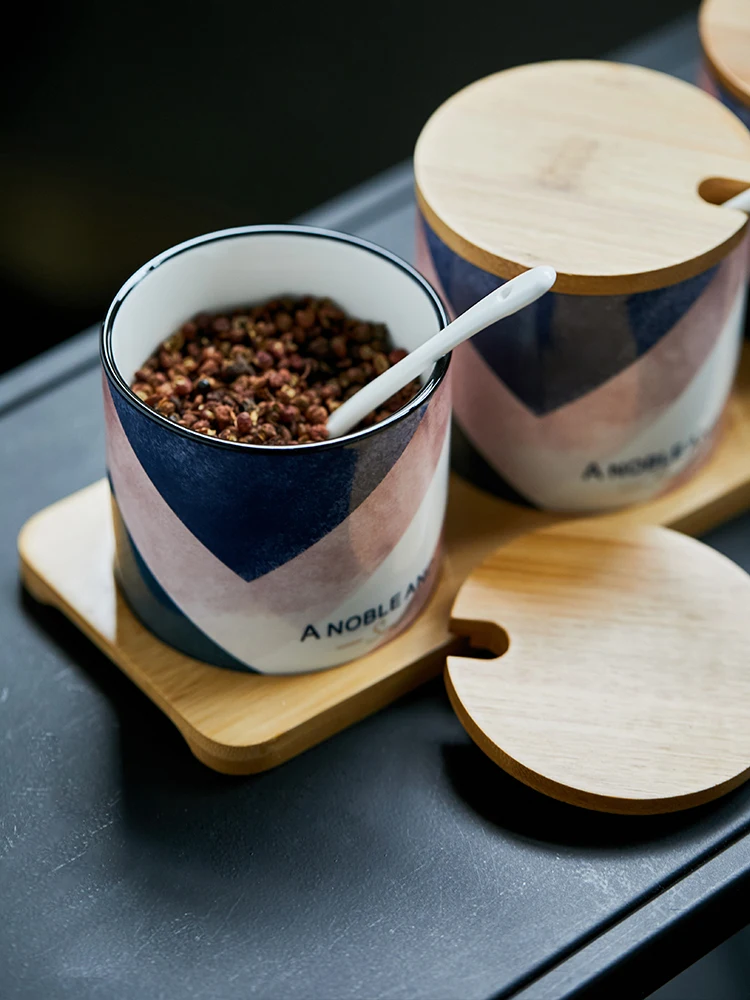 3 керамические банки для пряностей с деревянной крышкой в скандинавском стиле с геометрическим принтом и ложками для хранения соусов в кухонном наборе.