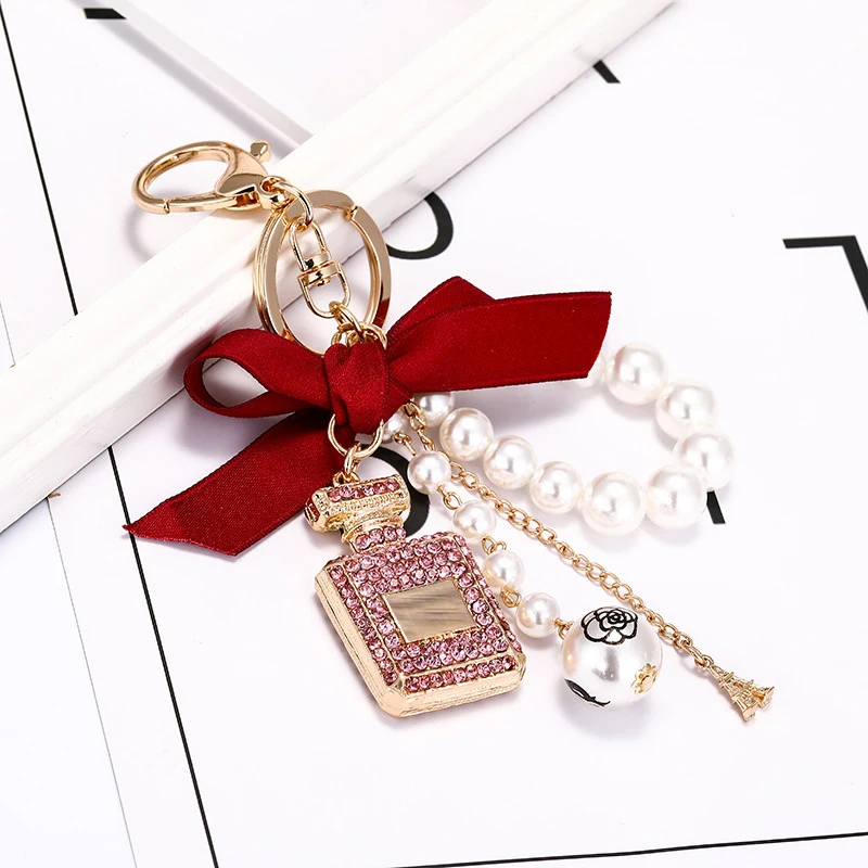 Creative hand-studded perfume bottle alloy key chain charm bow pearl pendant ladies bag mobile phone case pendant Birthday Gift