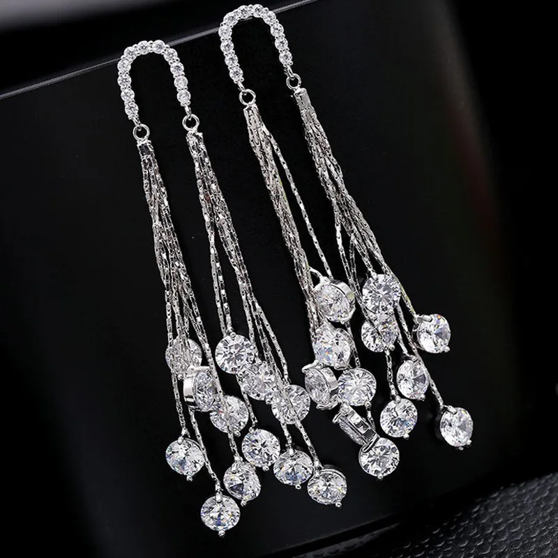 Женские серьги гвоздики серебряного цвета длинные с кисточками и блестящим