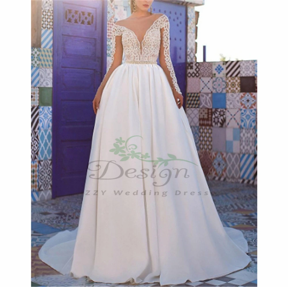 Роскошное белое свадебное платье с длинными рукавами украшенное бусинами и