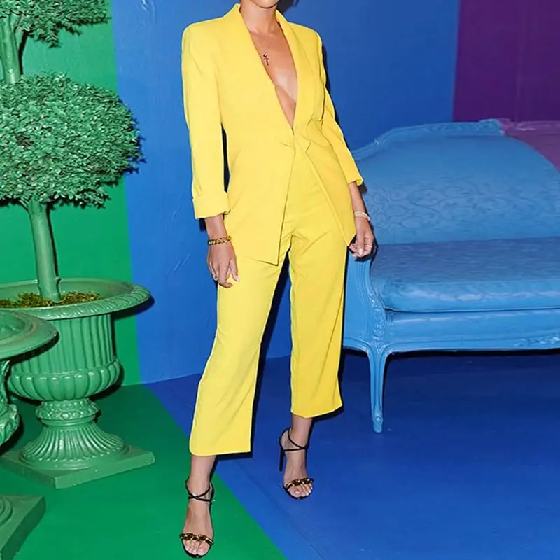 Женский костюм желтый с глубоким треугольным вырезом и штанами для интервью