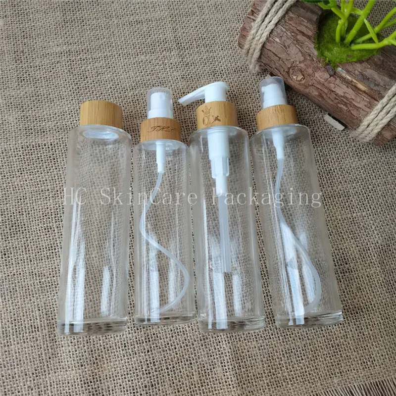 Hot sale flat shoulder clear glass lotion bottle with 24/410 bamboo lid and pump cosmetic packaging bottle for oil