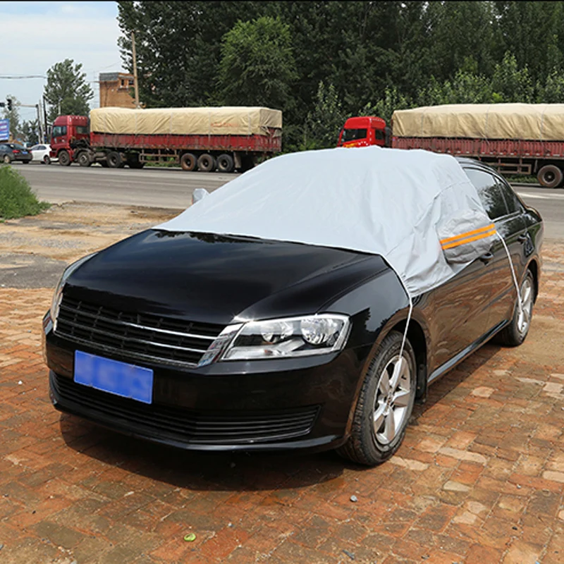 Зимний утепленный чехол для защиты от мороза наполовину покрывает автомобиль на