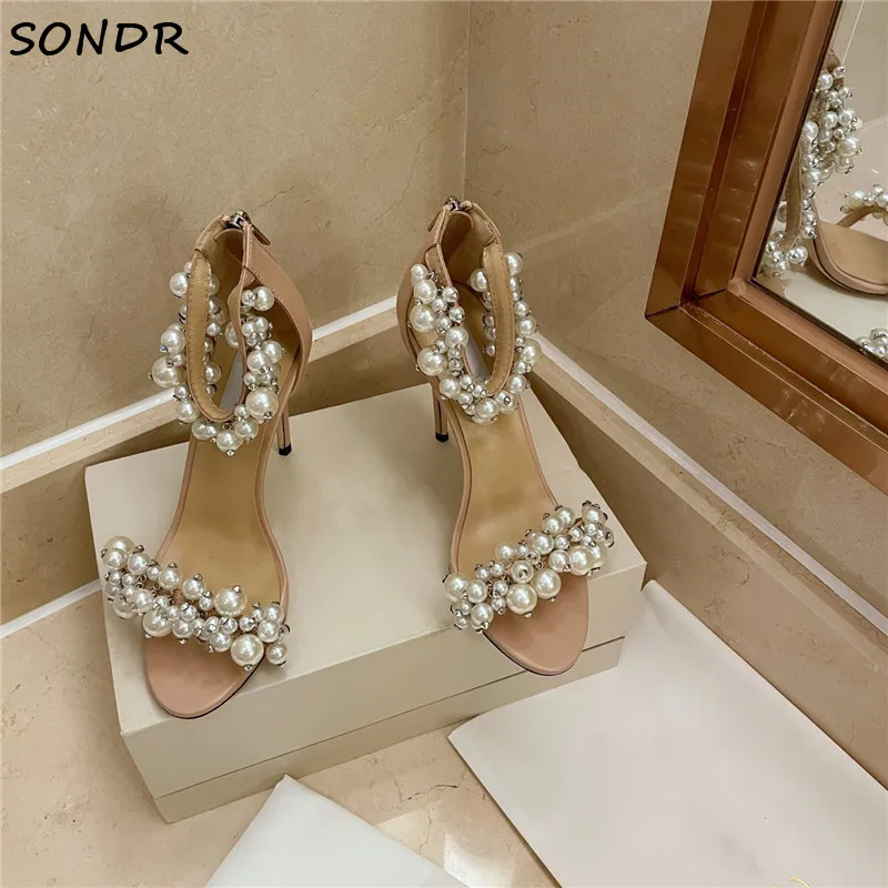 

Сандалии женские из натуральной кожи, белые, с жемчугом, модные свадебные босоножки на высоком каблуке, пикантная Дизайнерская обувь для ве...