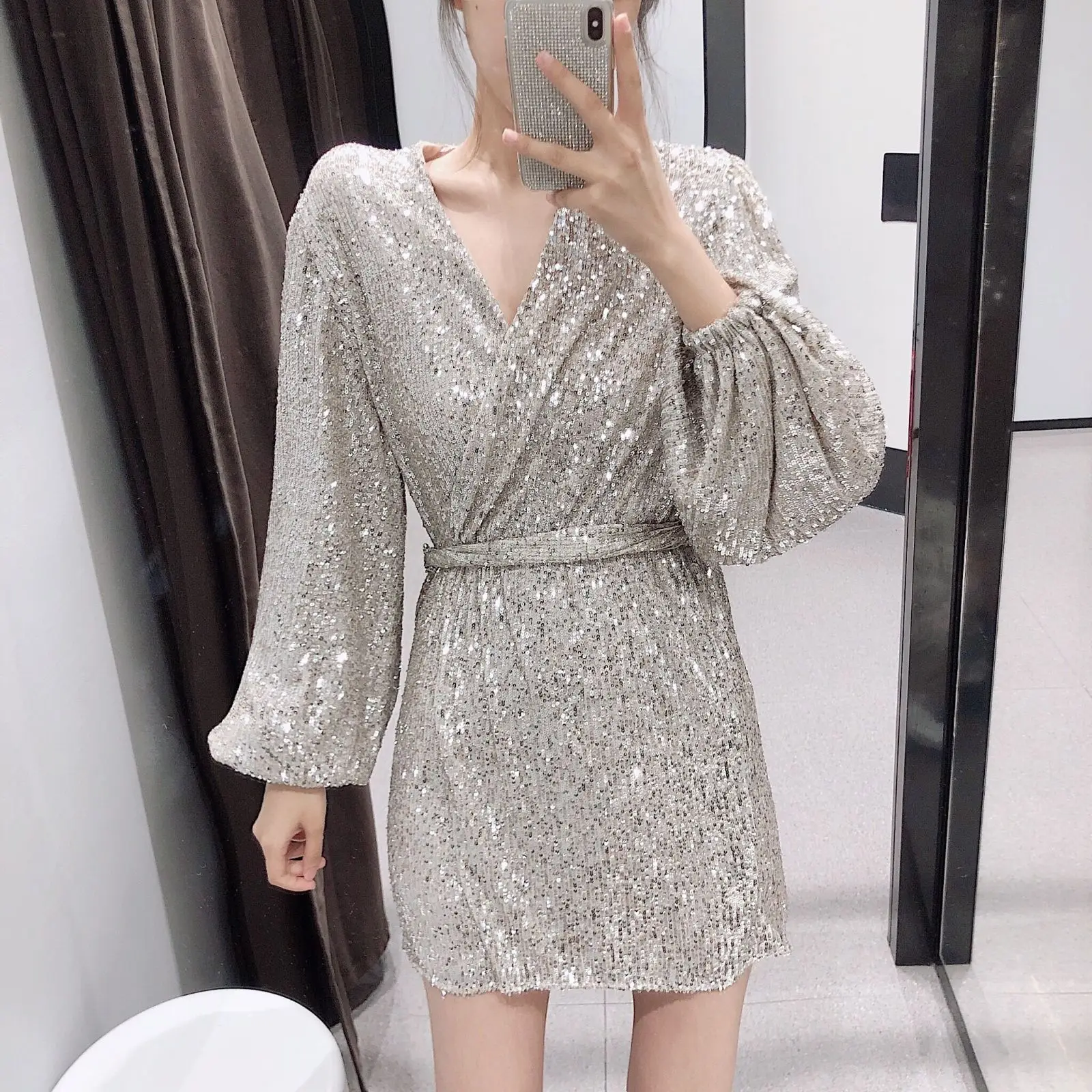 Соблазнительное серебристое платье с блестками и глубоким v-образным вырезом