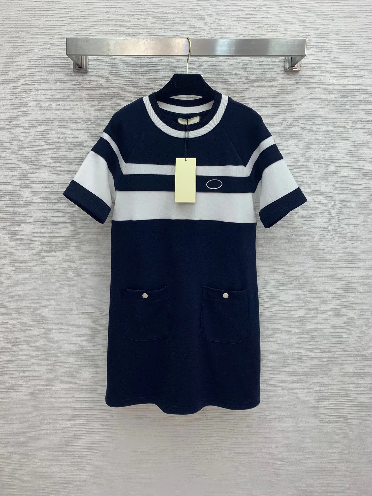 

Высококачественное платье с цветным логотипом на груди, двойными карманами, пуговицами и выгравированными буквами, круглым вырезом и корот...