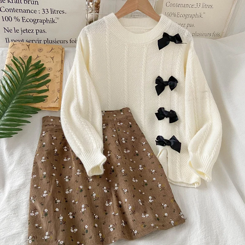 

Женский вязаный свитер с бантом и юбка с цветочным принтом