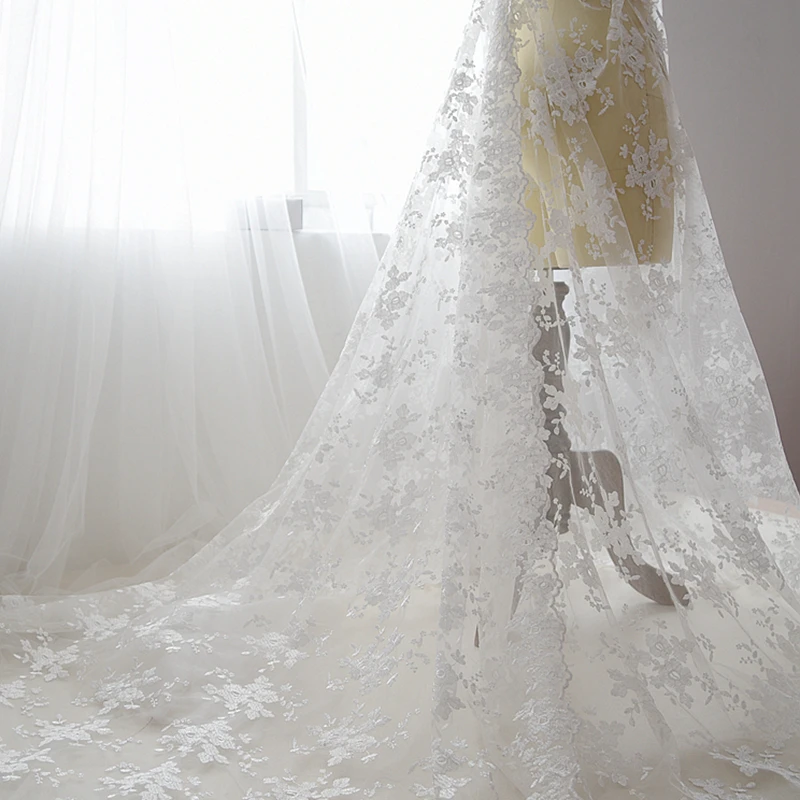Незамкнутая белая вышитая кружевная ткань для шитья свадебного платья фоновая