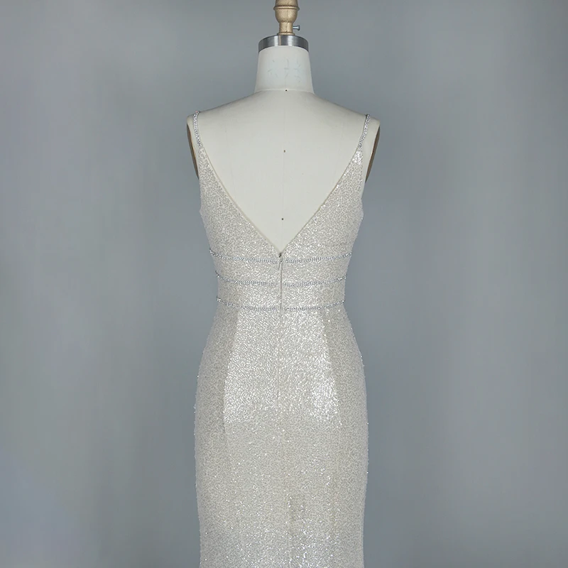 Женское вечернее платье белого цвета с глубоким v образным вырезом и блестками