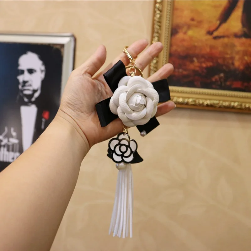 

Korean Simple Fashion Couple Friend Party Gift Leather Tassel Black And White Camellia Bag Mobile Car Key Chain Pendant K20038