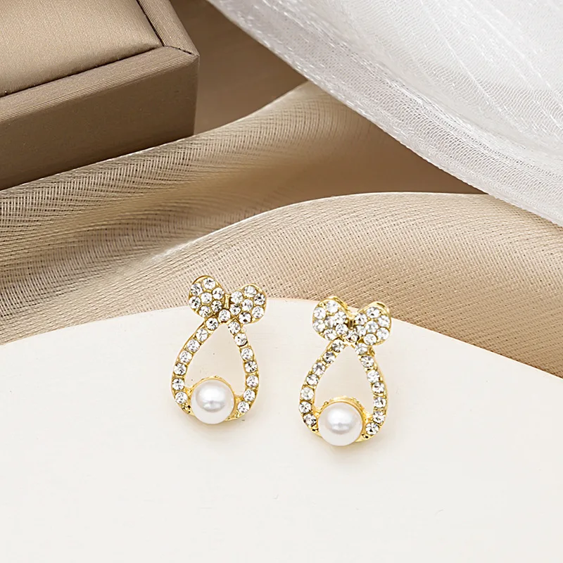 

U-Magical Exquisite Hollow Bow-knot Rhinestone Stud Earring for Women Simulation Pearl Gold Metallic Party Earring Jewellery