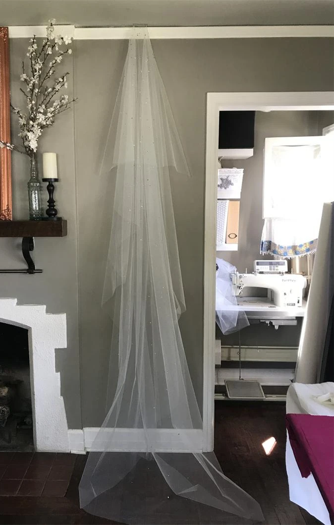 Двухслойный вуаль из мягкого тюля с кристальными каплями на свадьбу в простом кафедральном стиле.