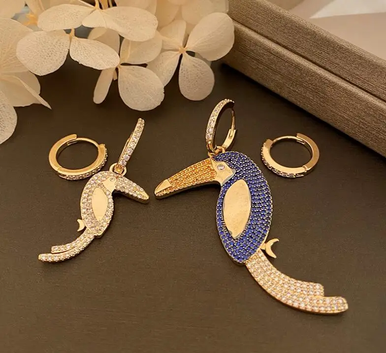 

Женские асимметричные серьги-гвоздики в виде ракушек Тукан со стразами