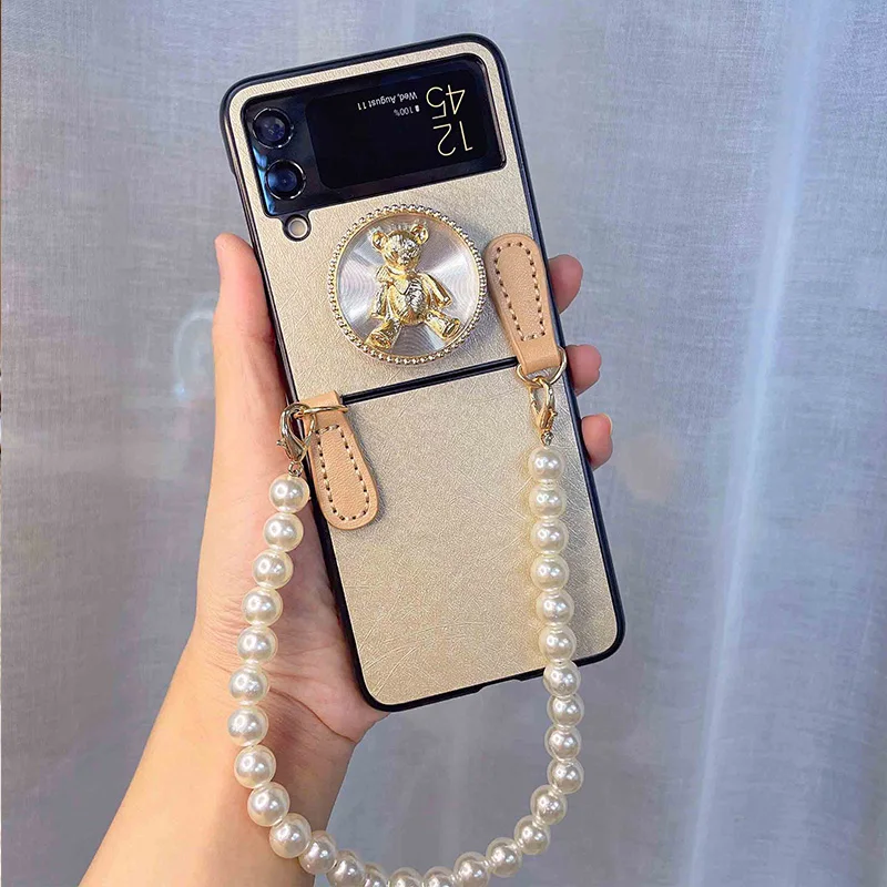 

Elegant Pearls Wrist Chain With Bear Bracket Phone Case For Samsung Galaxy Z Flip 3 5G Champagne Silk Print PU Leather Cover