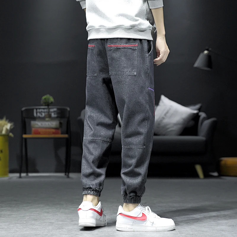 Мужские синие джинсы на диване с черной стенкой штаны завязками лодыжке мужские