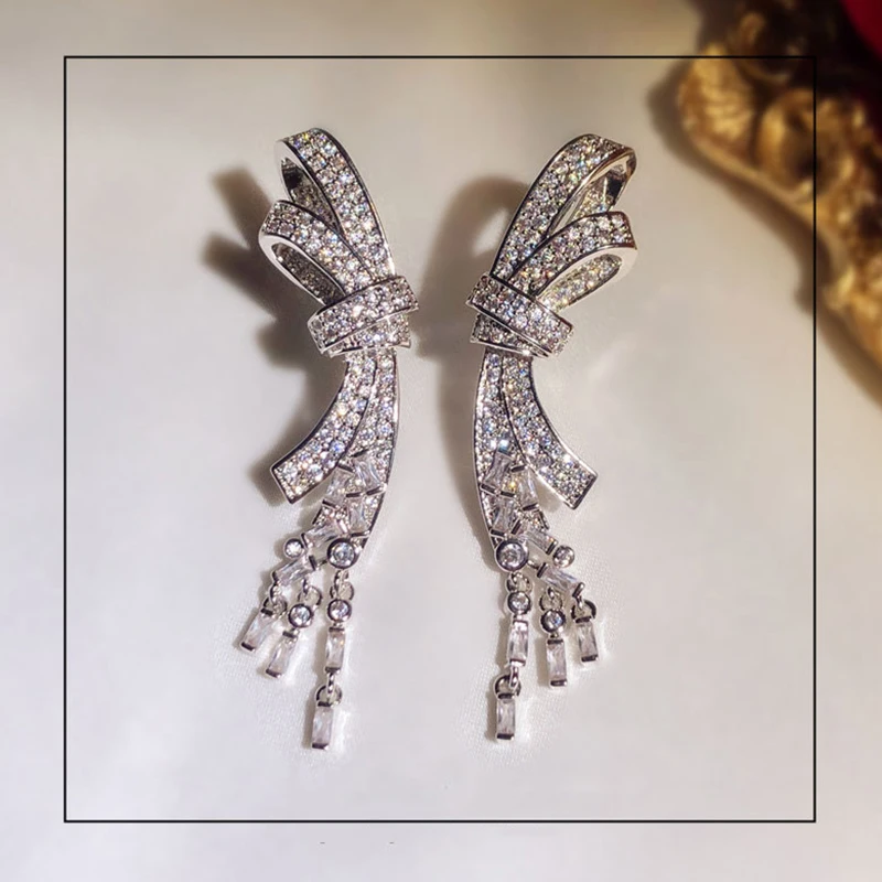 

Милые серьги-гвоздики серебряного цвета с украшением из циркония и камня в форме банта с длинной кисточкой для женщин Модная бижутерия коре...