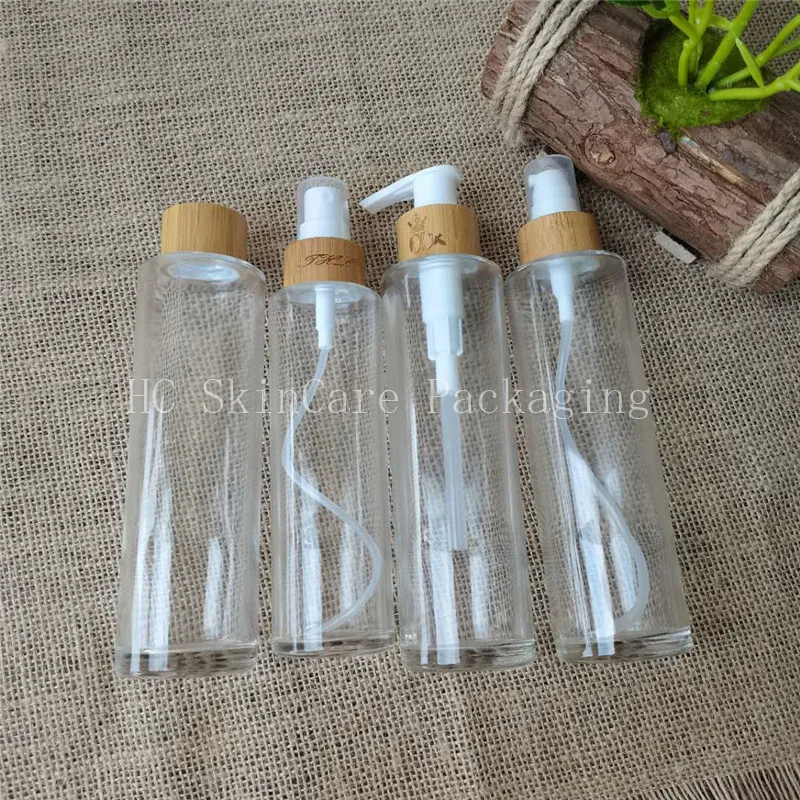 

Hot sale flat shoulder clear glass lotion bottle with 24/410 bamboo lid and pump cosmetic packaging bottle for oil
