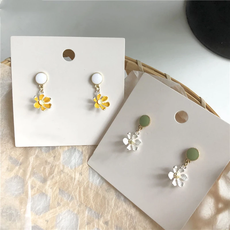 Сладкий белого и желтого цвета украшенное цветочными лепестками серьги-капельки