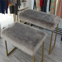 articles placed long plush artificial fur table top covered with fluffy blanket rectangular fluffy cushion