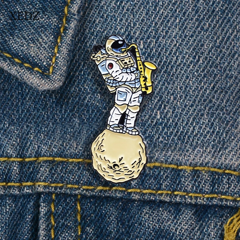 

XEDZ Fun astronaut blowing saxophone enamel pin fashion cartoon children's denim clothes lapel pendant jewelry gift on space pla