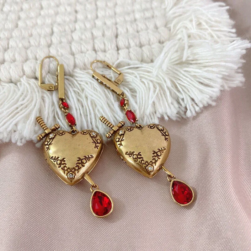 

Женские серьги в форме сердца с красными камнями